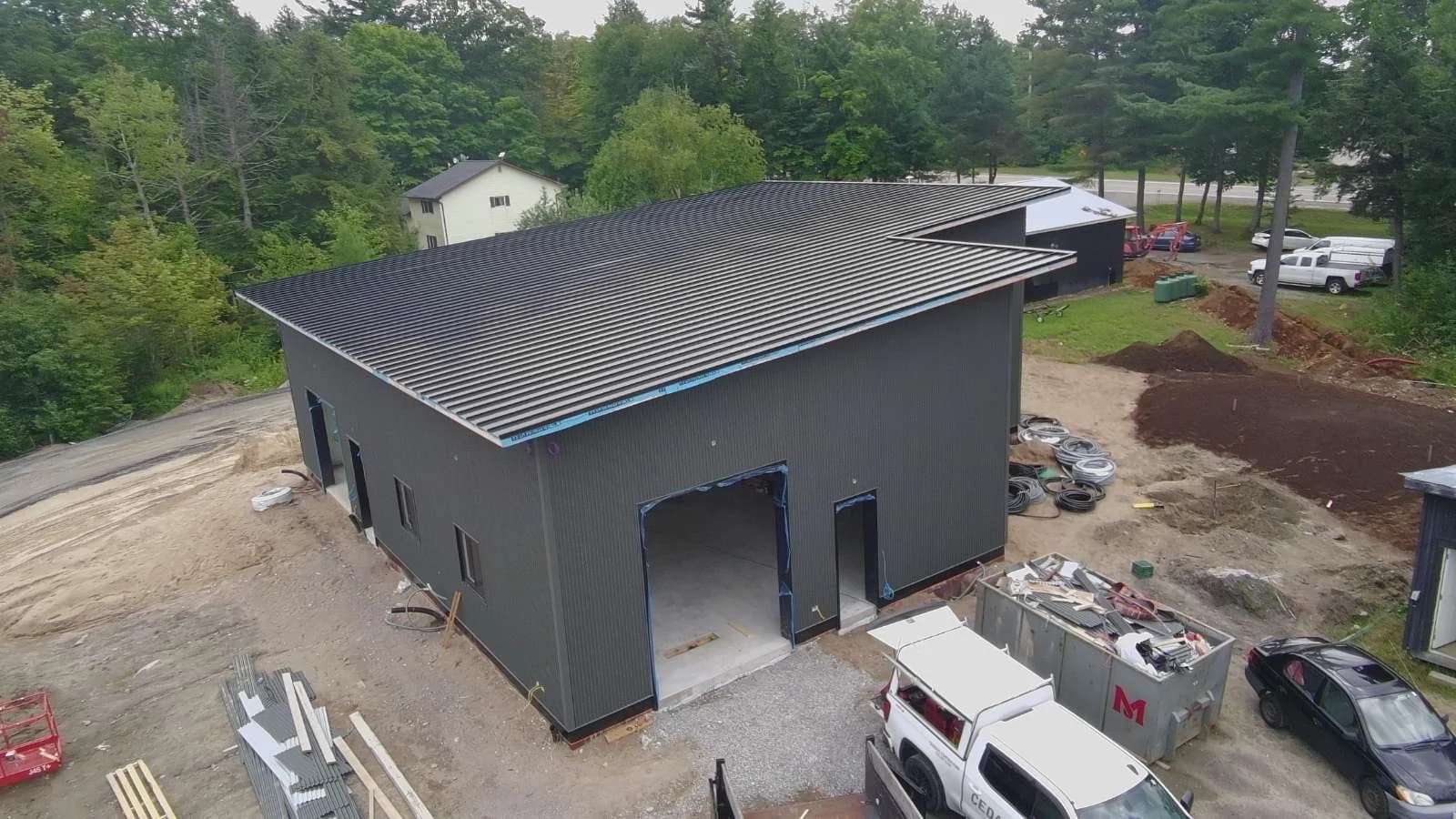 Aerial view of a dark metal roof and matching siding on a two-storey building