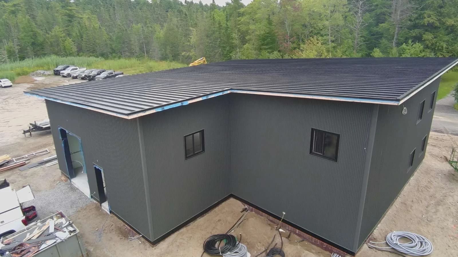 Dark metal siding and roof wrapping an L-shaped building