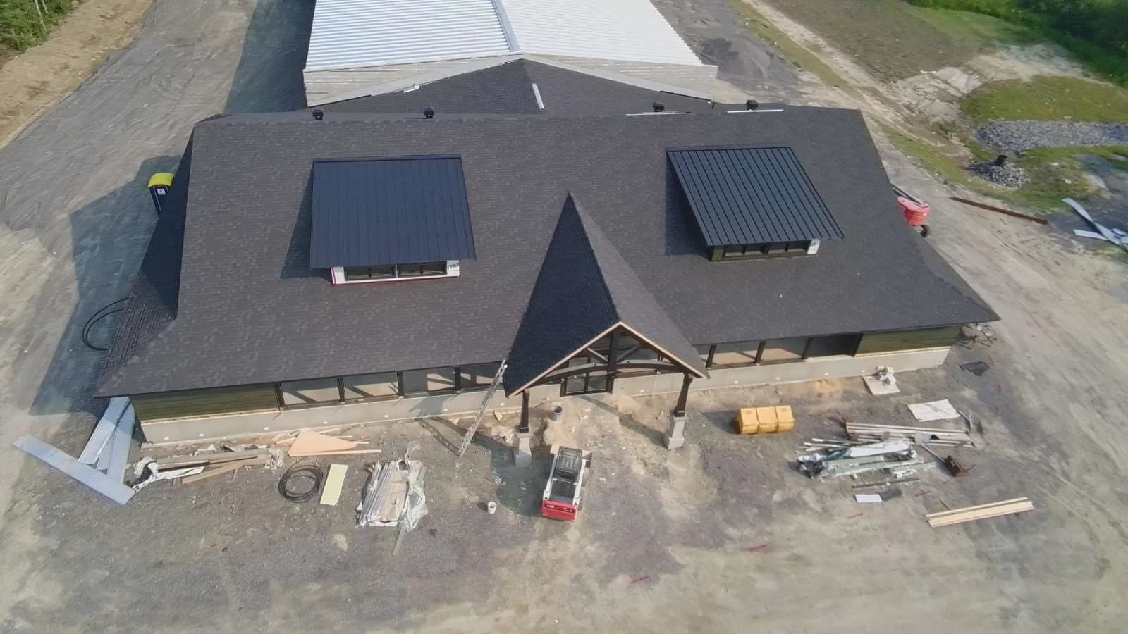 Overhead view of two metal dormer roofs within a shingled roof