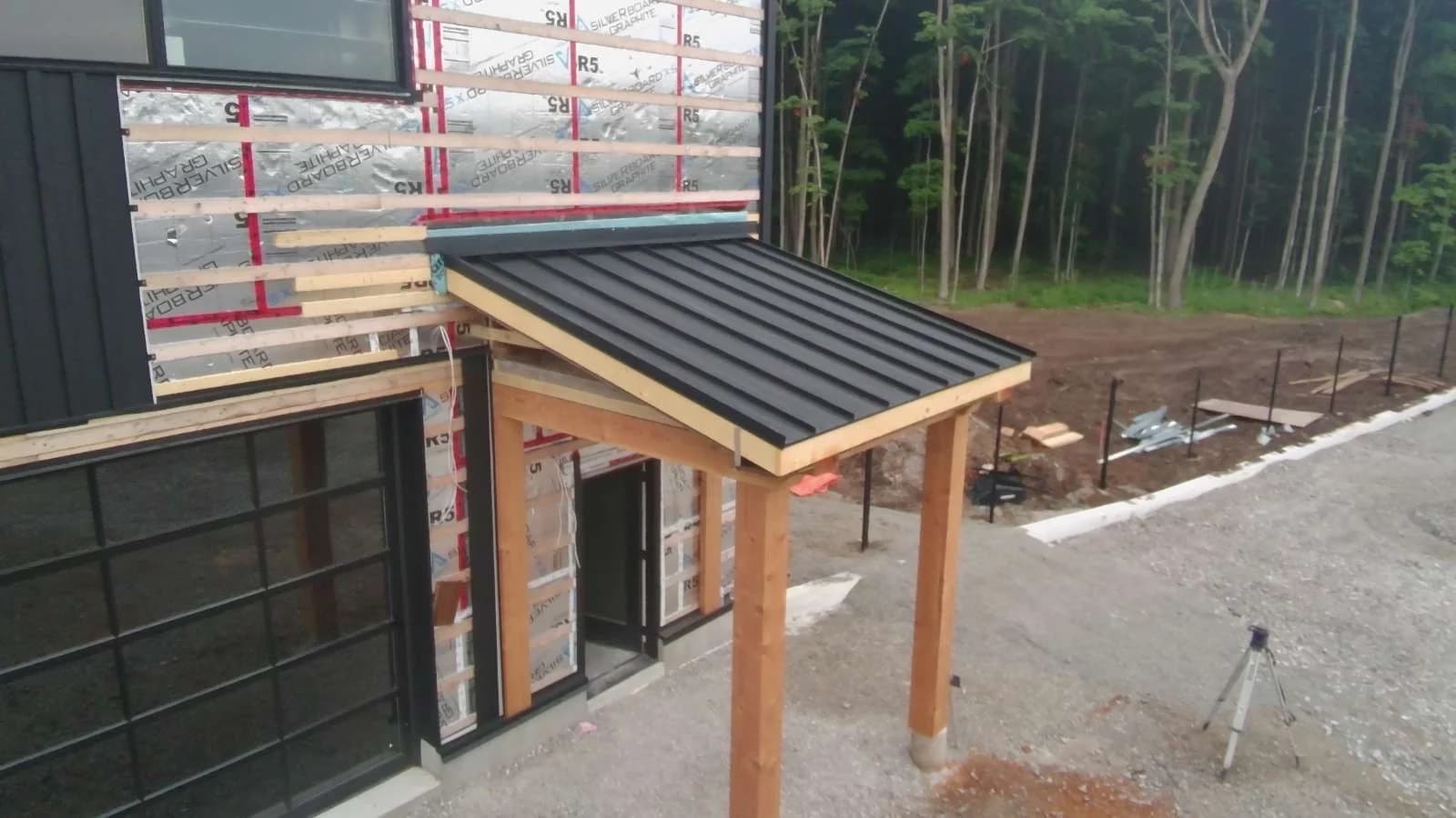 Standing seam canopy above a timber-framed entrance