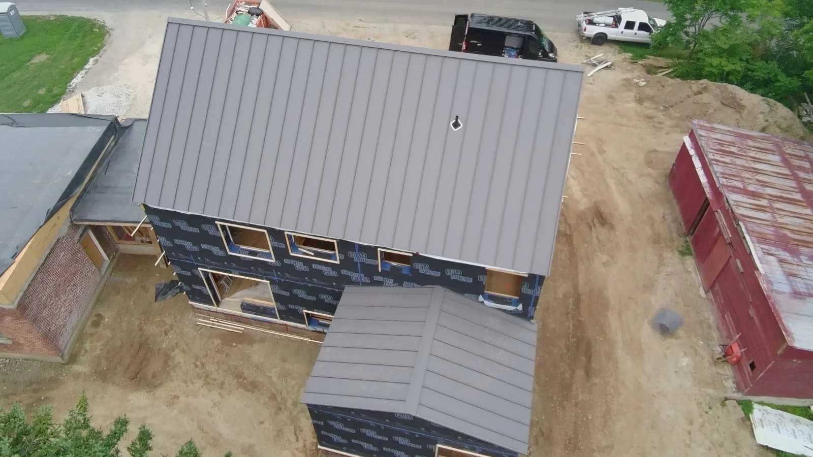 Top-down view of a metal roof and chimney during construction