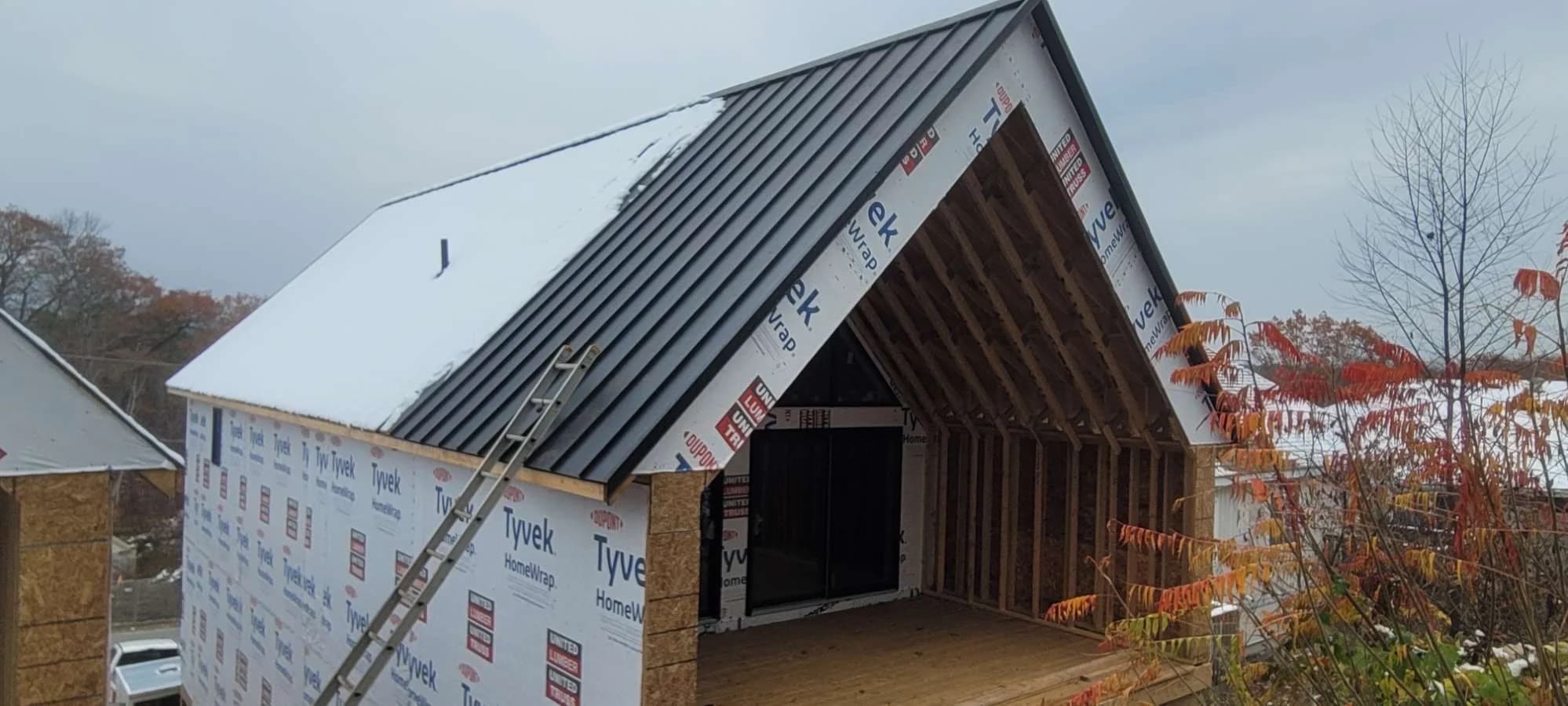 Standing seam roof installation on a steep timber-framed gable