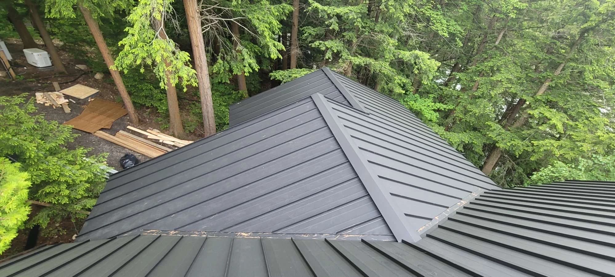 Precisely aligned metal roof hips surrounded by woodland