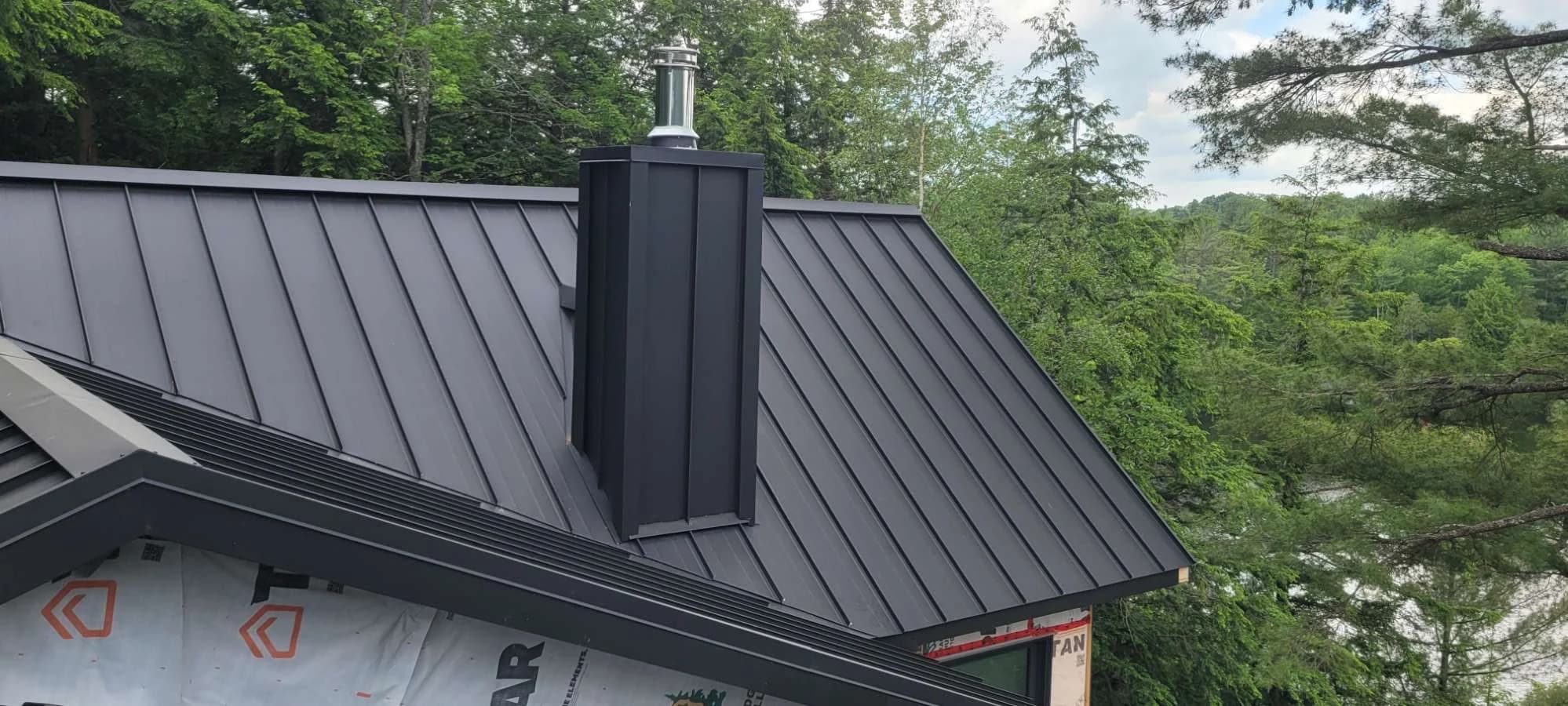 Standing seam roof with a metal-clad chimney