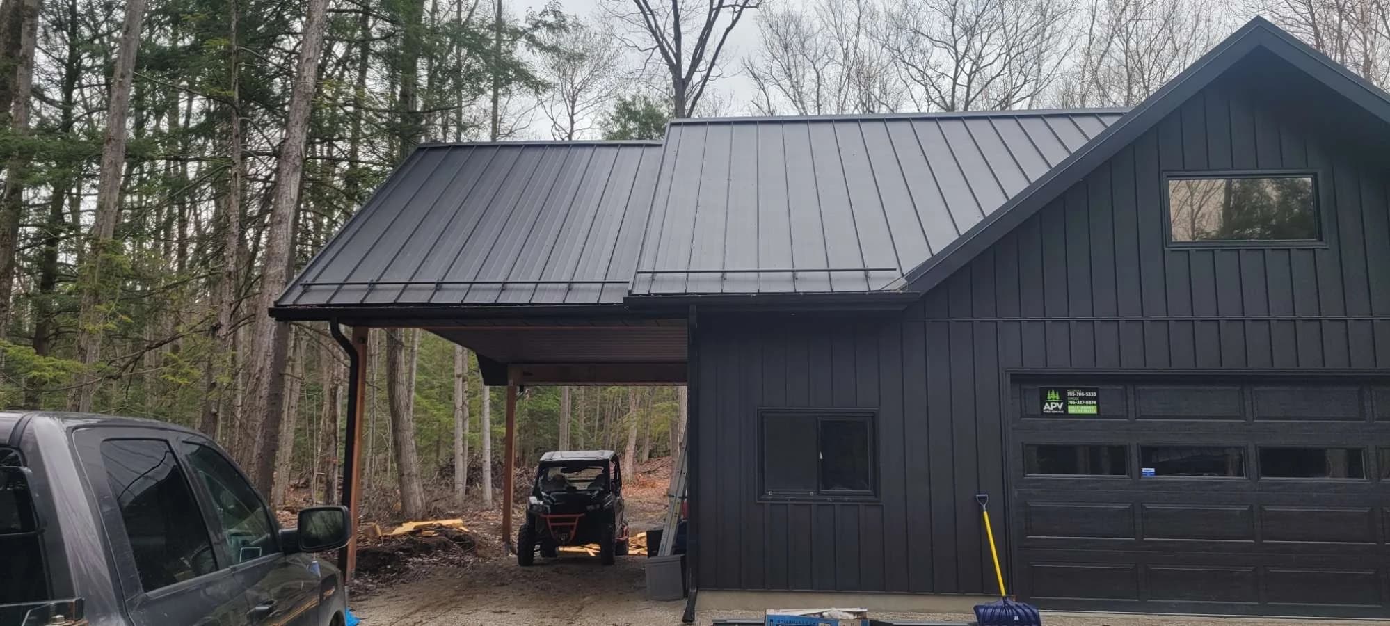 Dark metal roof and siding on a woodland garage