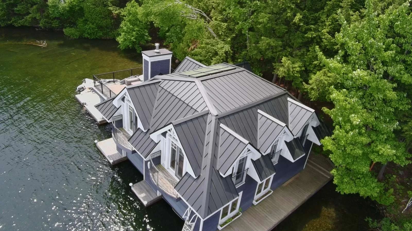 Completed standing seam roof with intersecting gables on a waterfront residence