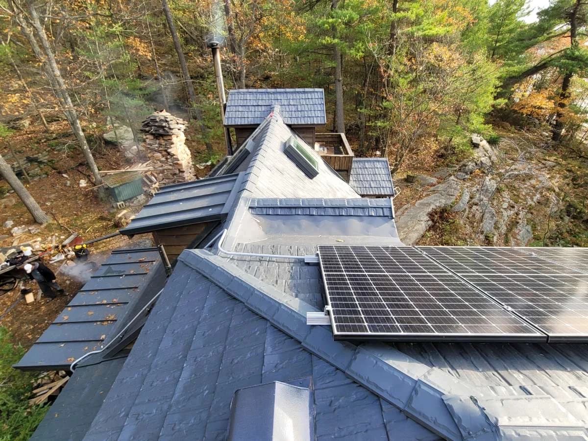 Metal shingle roof with a solar panel and intersecting rooflines