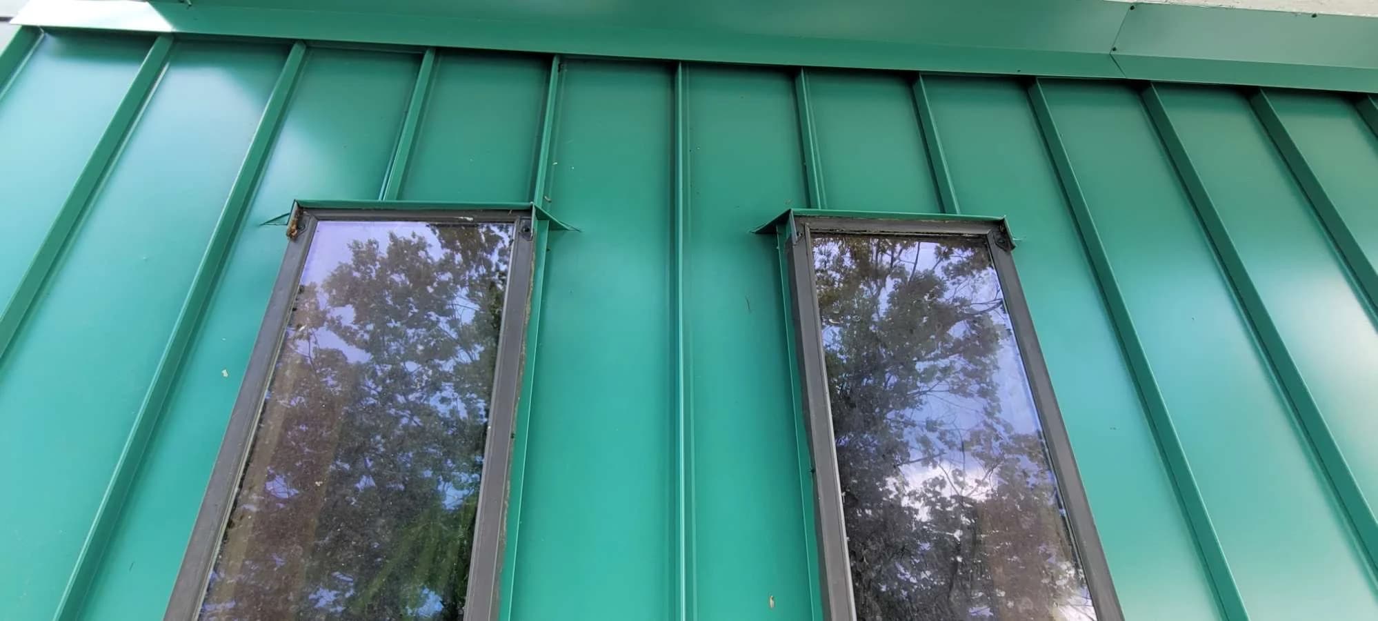 Skylight flashing set into a green standing seam roof