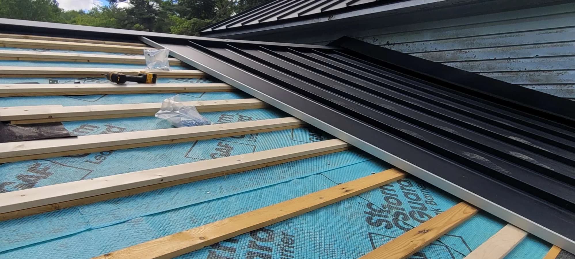 Metal roofing installation with supporting battens and membrane visible