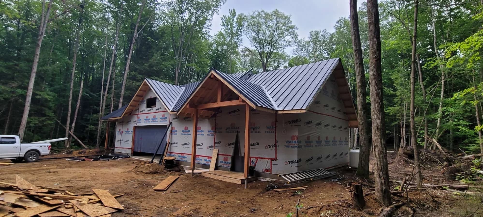 Metal roof across a woodland home under construction
