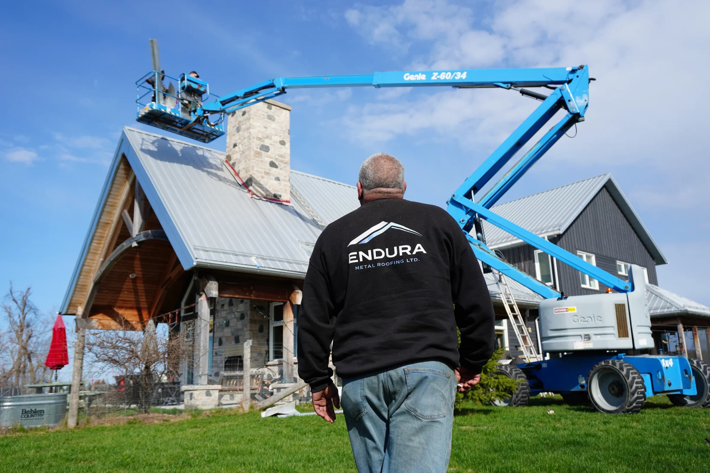 Ken, seen from behind in his Endura jacket, looking up at a roof on site