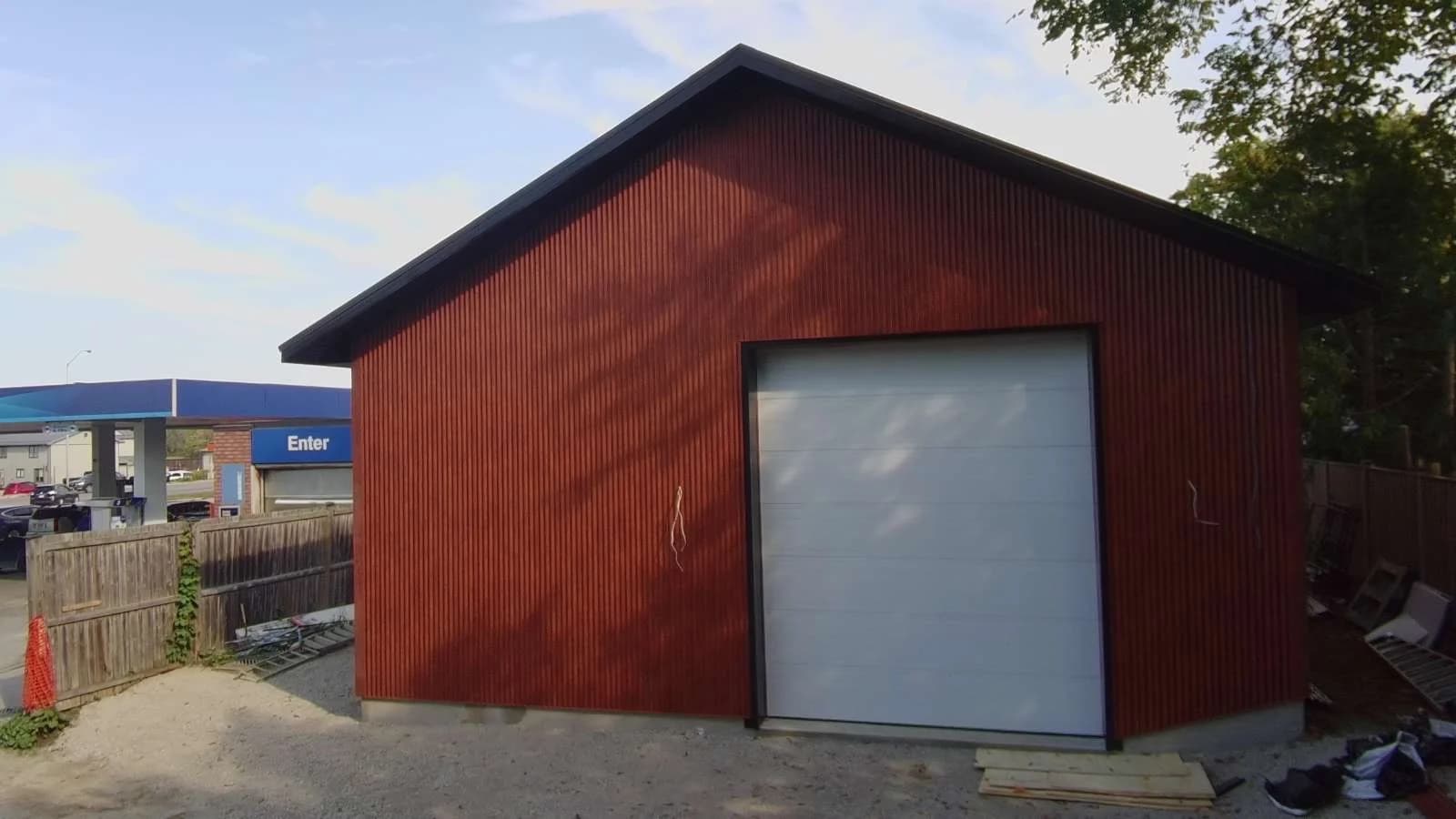 Wood-look metal siding on a garage with a grey door